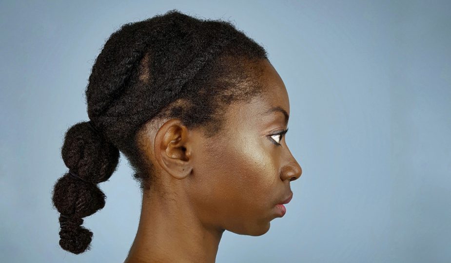 From A to 4z standing in profile showing off a ponytail banded with elastic bands for the protective style challenge